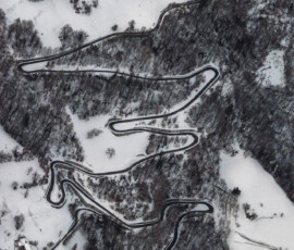 la strada si adatta al pendio con curve e tornanti resi quasi inspiegabili dalla prospettiva della fotografia aerea dalla mongolfiera