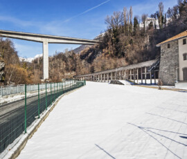Aosta-Saumont: da destra, la vecchia centrale, dismessa e restaurata, con il canale sopraelevato di alimentazione; il viadotto che collega l'autostrada a Via G. San bernardo, il nuovo tratto di strada per il Poligono